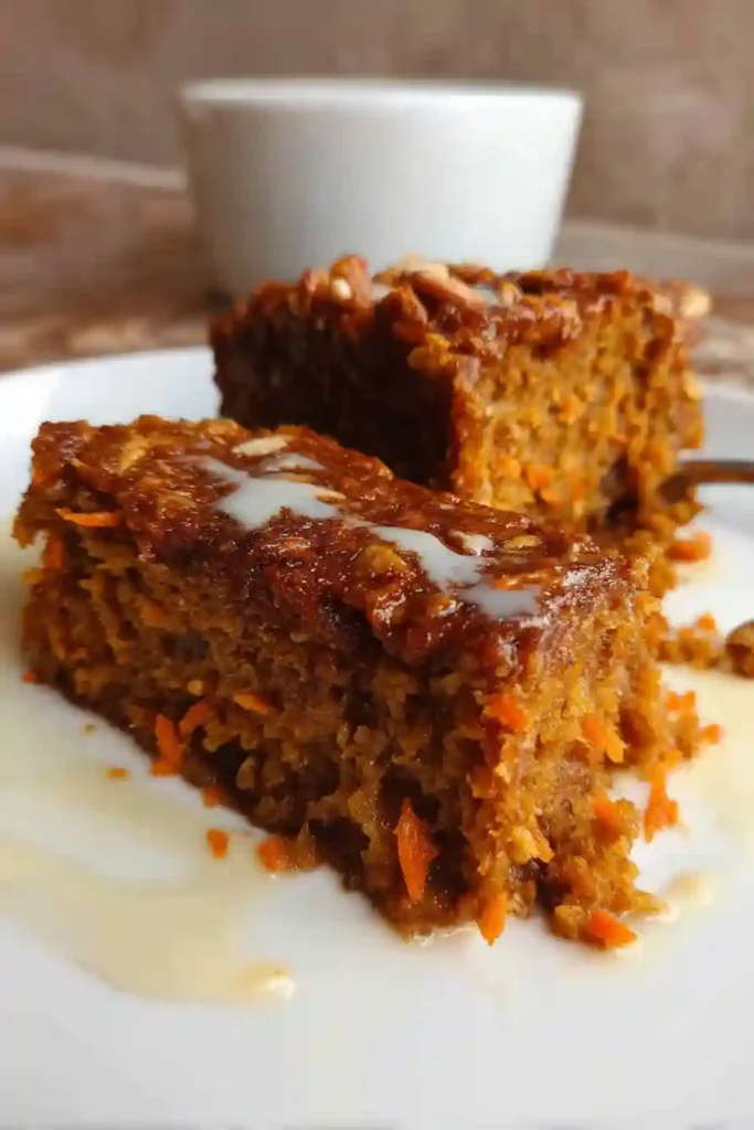 Slice of warm carrot cake baked oatmeal on plate with cream cheese topping and fork taking first bite